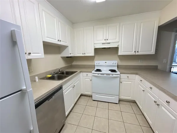 a kitchen with cabinets appliances a sink and a counter space