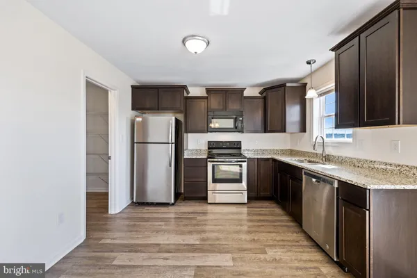 a kitchen with a refrigerator sink and cabinets