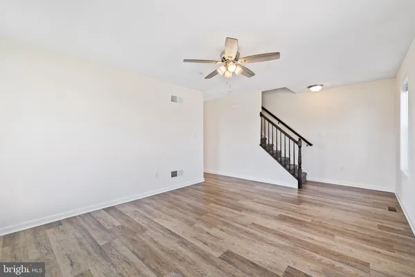 an empty room with a ceiling fan and a window
