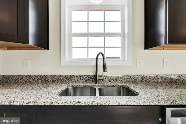 a kitchen with granite countertop a sink and a window