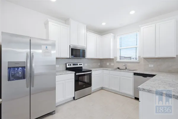 a kitchen with cabinets and stainless steel appliances