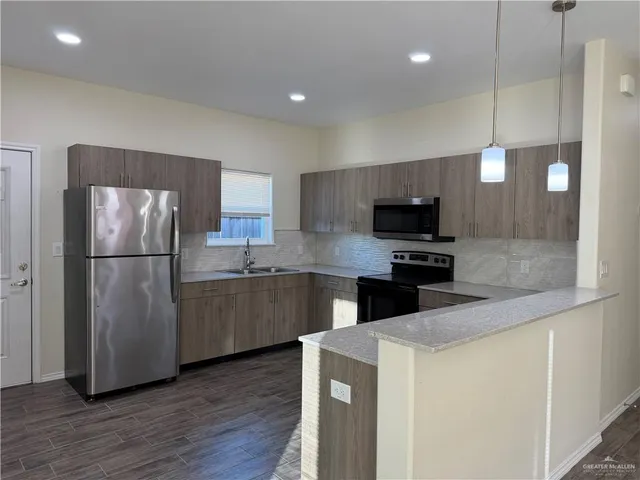 a kitchen with granite countertop a refrigerator and a sink