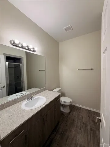 a bathroom with a double vanity sink toilet and mirror