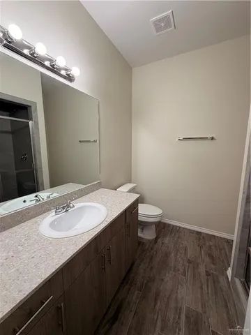 a bathroom with a sink a toilet a mirror and vanity