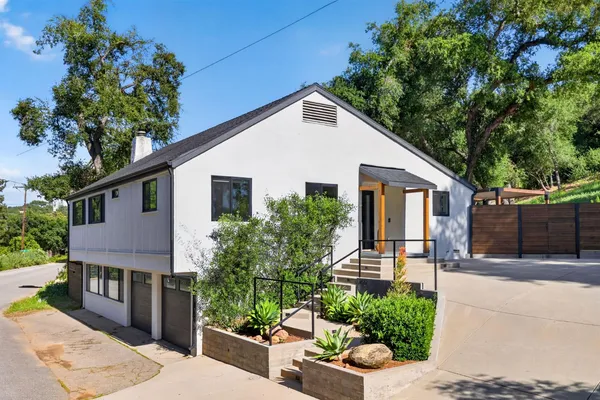 a view of a house with a yard and potted plants