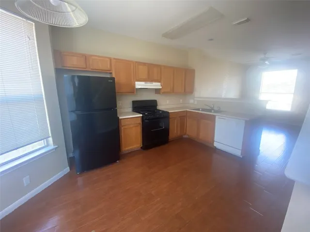 a kitchen with stainless steel appliances a refrigerator a sink a stove a microwave a counter top and cabinets