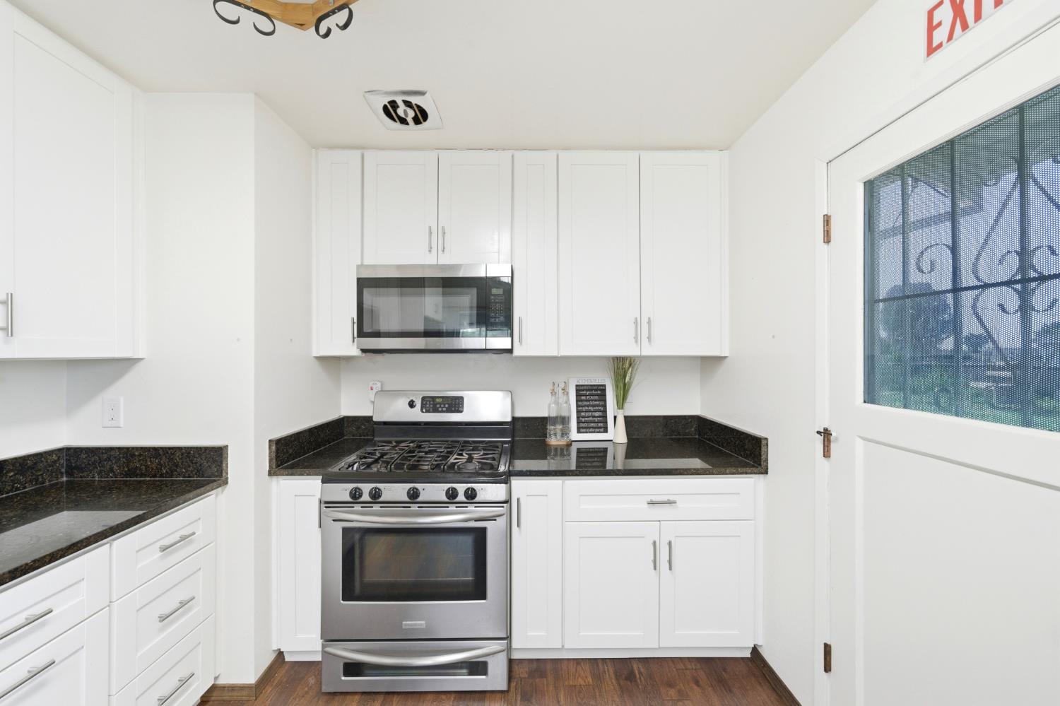 6515 West 4th Street Rio Linda, CA 95673 - Photo 26 of 97 a kitchen with granite countertop white cabinets and white appliances