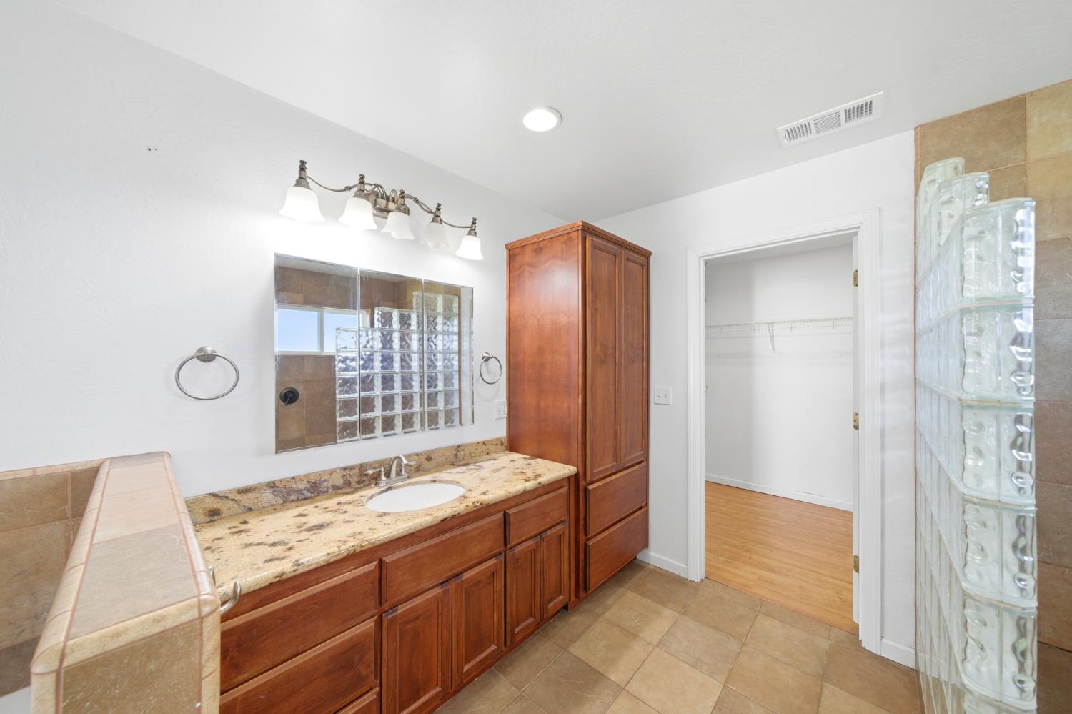 6515 West 4th Street Rio Linda, CA 95673 - Photo 65 of 97 a spacious bathroom with a granite countertop sink a mirror and a shower