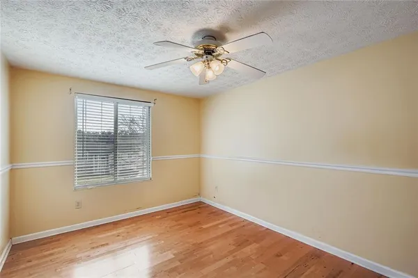 an empty room with a window and a ceiling fan