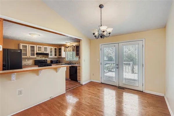 a view of a kitchen with stainless steel appliances granite countertop a refrigerator a stove a sink dishwasher with wooden floor and cabinets