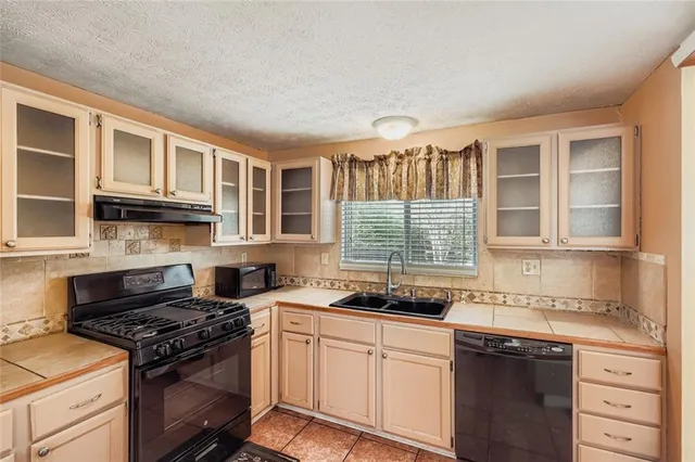 a kitchen with stainless steel appliances granite countertop a stove and a sink