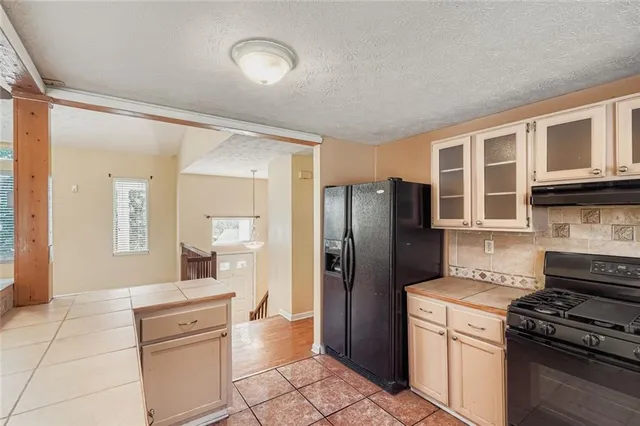 a kitchen with stainless steel appliances granite countertop a refrigerator and a stove top oven