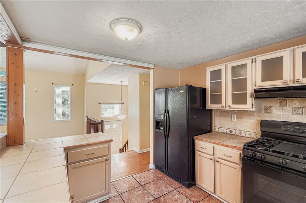 6134 Raintree Bend Lithonia, GA 30058 - Photo 10 of 17 a kitchen with stainless steel appliances granite countertop a refrigerator and a stove top oven