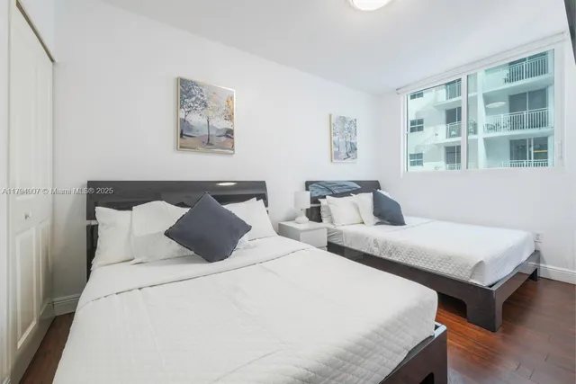 a bedroom with two beds and a window