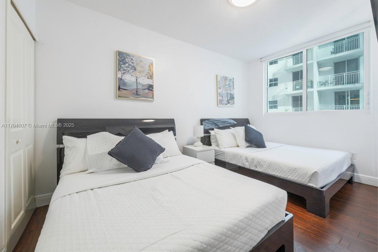 170 Southeast 14th Street, Unit 1905 Miami, FL 33131 - Photo 17 of 17 a bedroom with two beds and a window