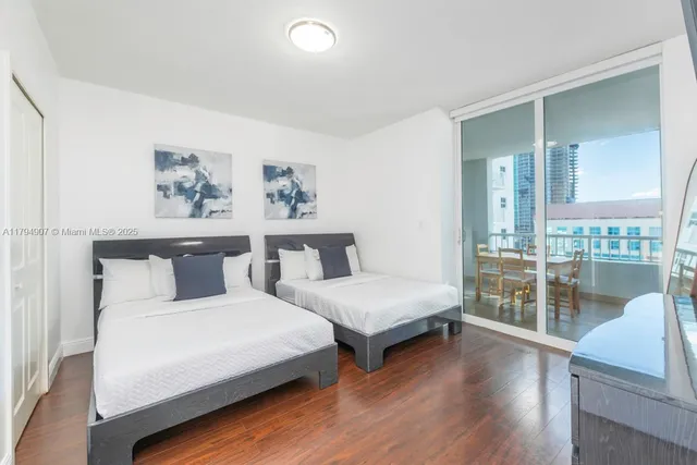 a bedroom with a large bed and a wooden floor