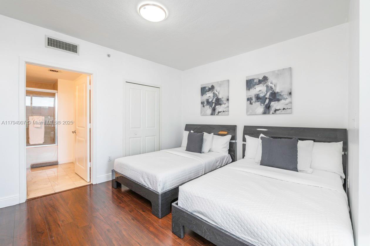 170 Southeast 14th Street, Unit 1905 Miami, FL 33131 - Photo 3 of 17 a bedroom with two beds and a painting on the wall