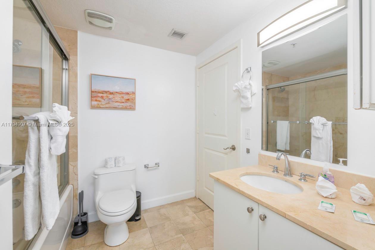 170 Southeast 14th Street, Unit 1905 Miami, FL 33131 - Photo 8 of 17 a bathroom with a granite countertop sink mirror vanity and toilet