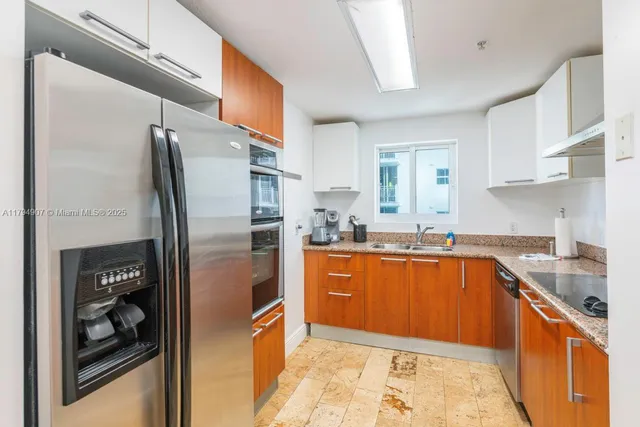 a kitchen with stainless steel appliances granite countertop a refrigerator and a sink