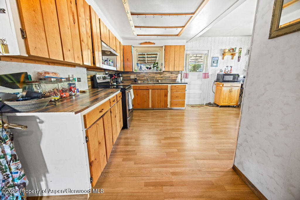 36 Collom Street Maybell, CO 81640 - Photo 20 of 43 a kitchen with stainless steel appliances a refrigerator and wooden cabinets
