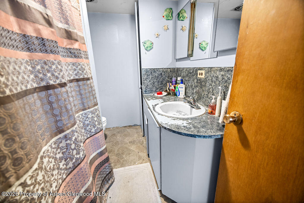 36 Collom Street Maybell, CO 81640 - Photo 35 of 43 a bathroom with a granite countertop sink and a mirror