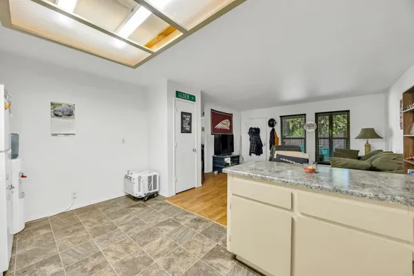 a room with kitchen island a sink and natural light