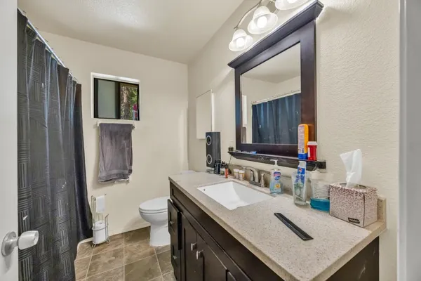 a bathroom with a sink vanity mirror and toilet
