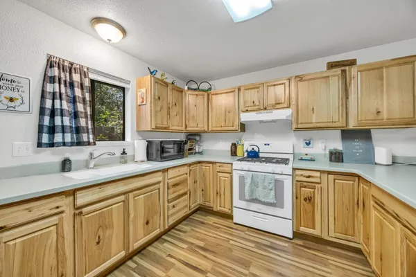 a kitchen with stainless steel appliances granite countertop a sink and cabinets with wooden floor