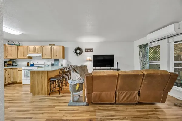 a living room with stainless steel appliances granite countertop a couch and a flat screen tv