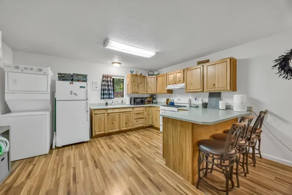 a kitchen with stainless steel appliances granite countertop a white cabinets and wooden floors