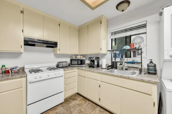 a kitchen with cabinets appliances a sink and a counter top space
