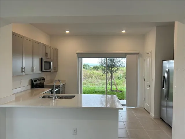 a view of a room with a large window and a way to kitchen