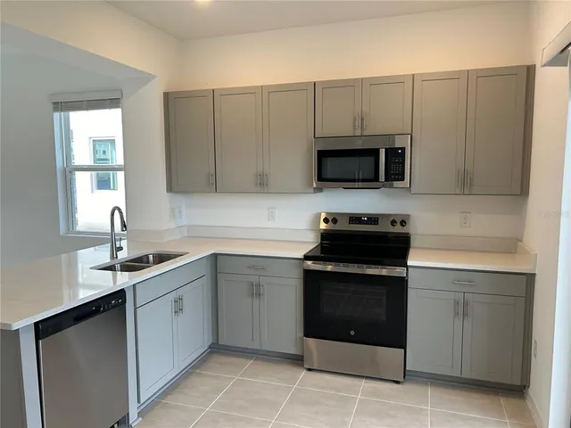 a kitchen with white cabinets and black appliances