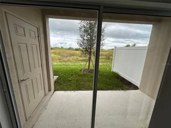 a view of a glass door with a yard from a window
