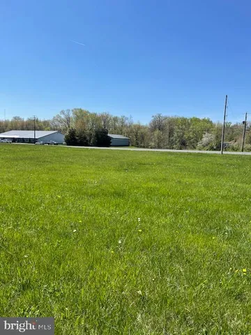 a view of a field of grass and trees