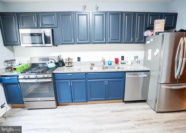 a kitchen with stainless steel appliances granite countertop a refrigerator microwave and sink