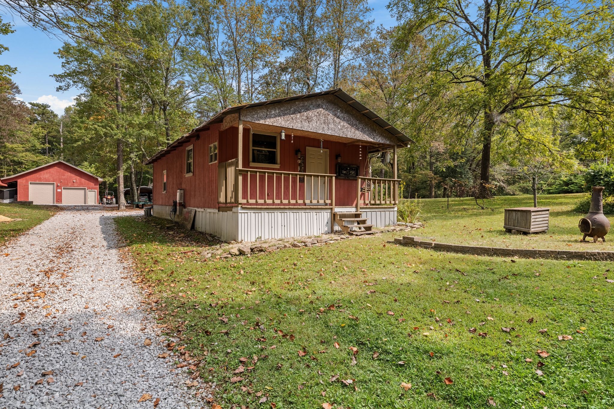 6245 Greentown Road Tracy City, TN 37387 - Photo 38 of 47 a backyard of a house with table and chairs under an umbrella
