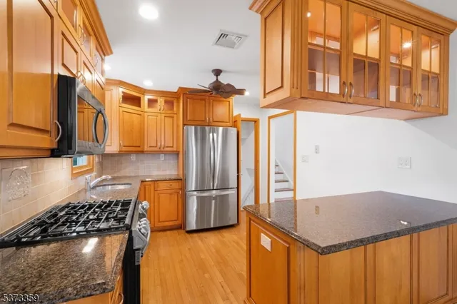 a kitchen that has a lot of cabinets and stainless steel appliances