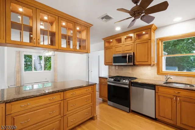 a kitchen with stainless steel appliances granite countertop a sink and a stove