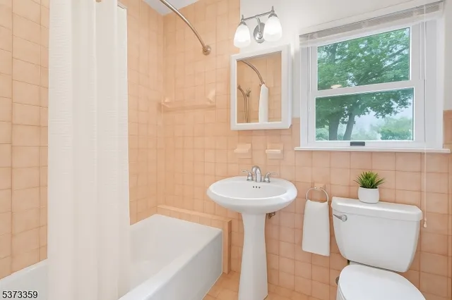 a bathroom with a sink and mirror with bathtub