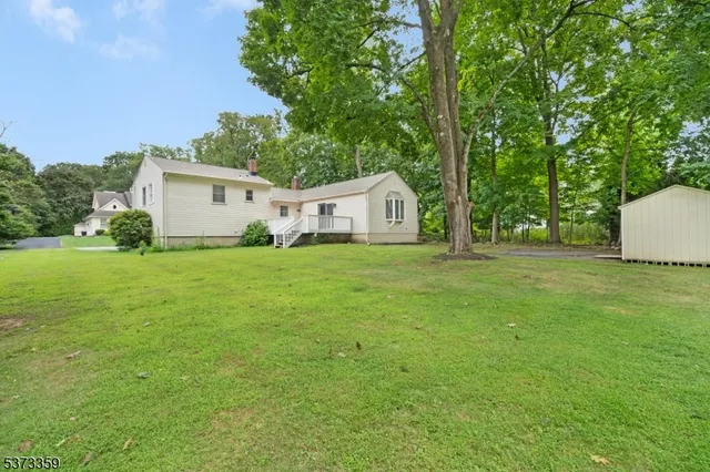 a white house that has a big yard with wooden fence