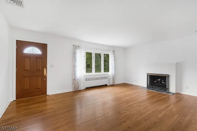 an empty room with windows and a fireplace