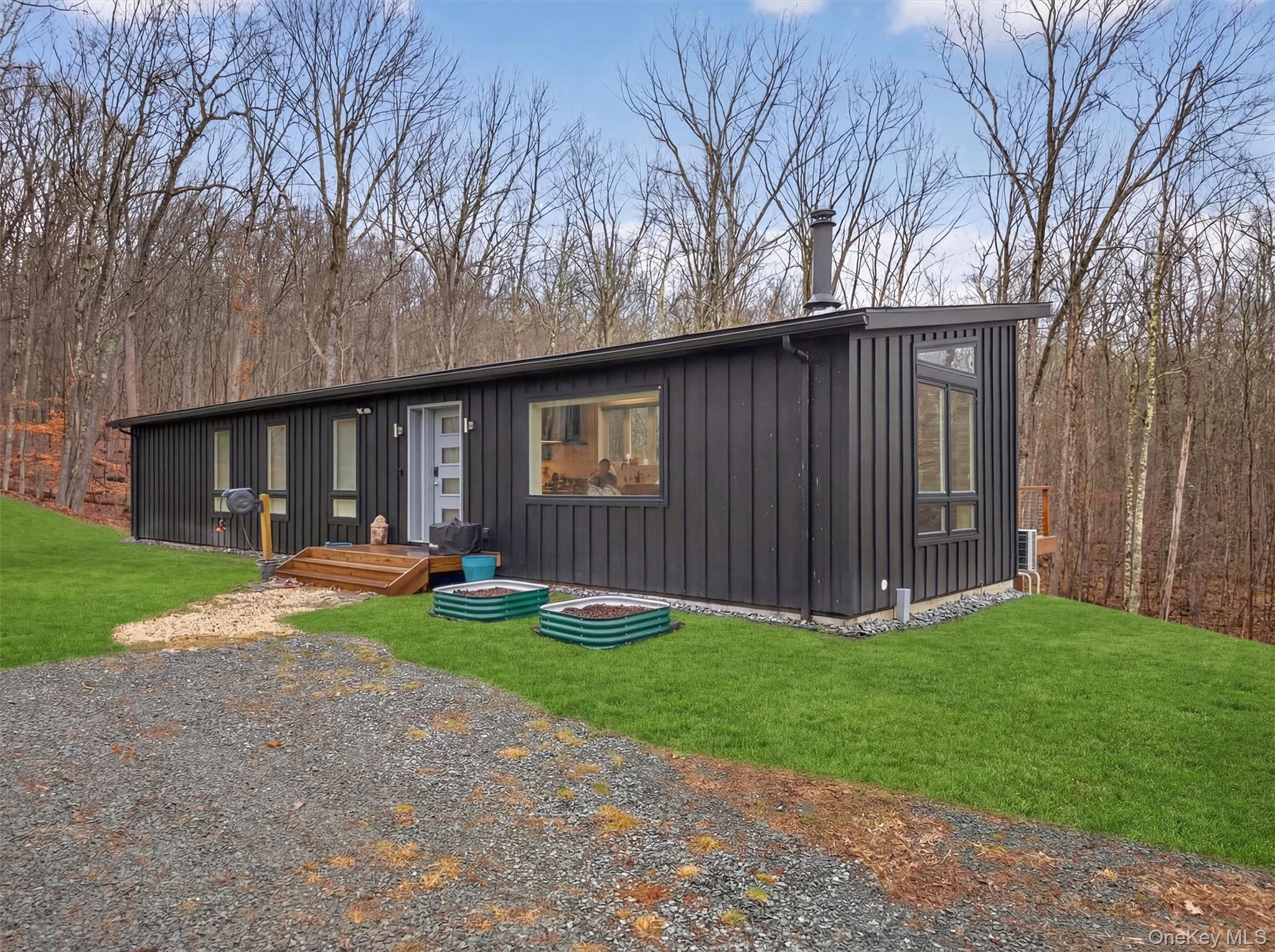 119 Lenni Lenape Road Narrowsburg, NY 12764 - Photo 5 of 40 Mid-century inspired home with a front lawn and board and batten siding, raised flower bins