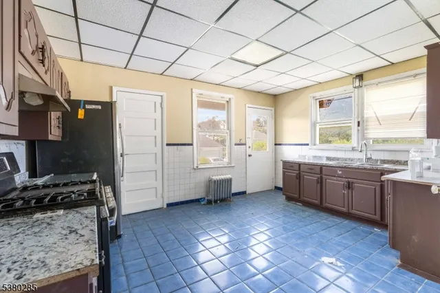 a large kitchen with a stove a sink dishwasher and a refrigerator