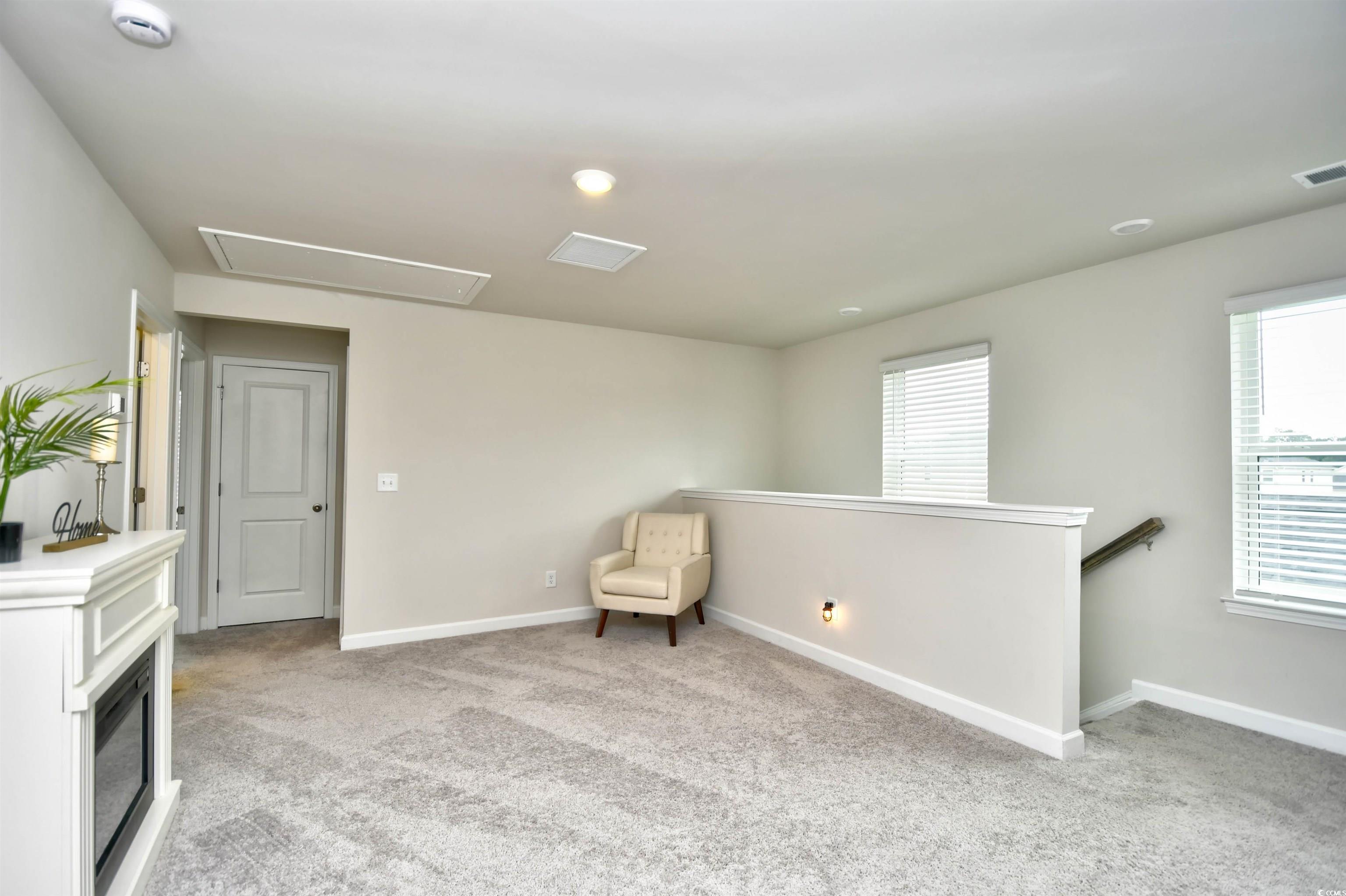2325 Copper Crk Loop Longs, SC 29568 - Photo 20 of 40 Unfurnished room with light colored carpet, attic access, an upstairs landing, recessed lighting, and a glass covered fireplace