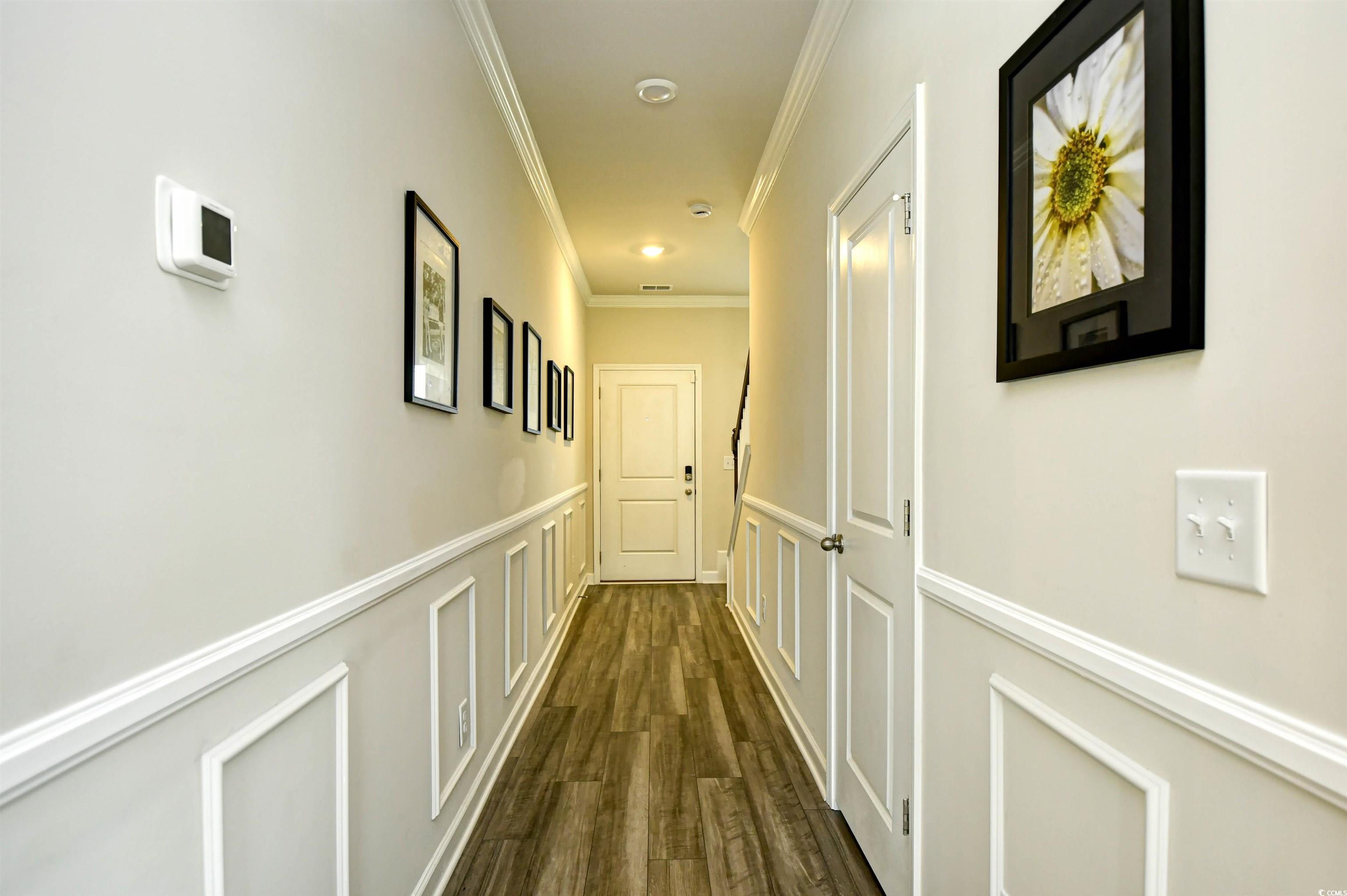 2325 Copper Crk Loop Longs, SC 29568 - Photo 5 of 40 Corridor with crown molding, dark wood-style floors, a wainscoted wall, and a decorative wall