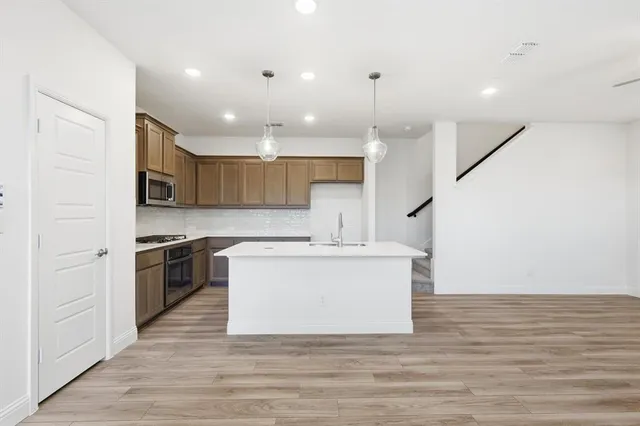 an empty room with wooden floor and a ceiling fan