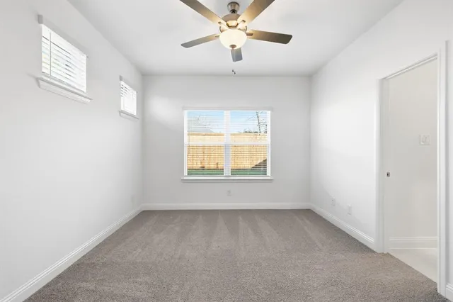 a large kitchen with granite countertop a white stove top oven and white cabinets