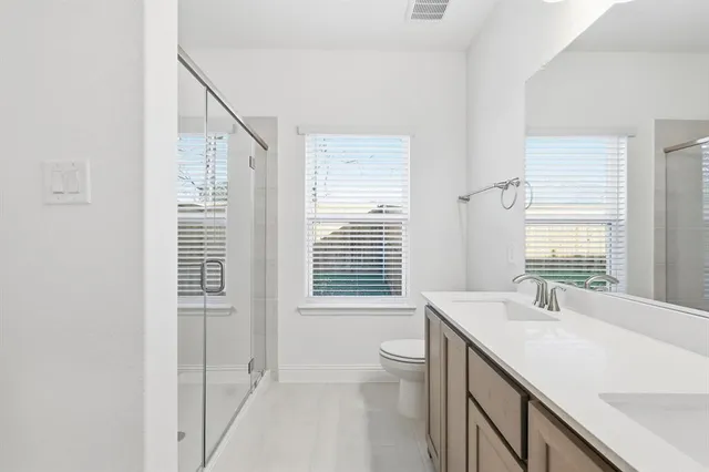 a bathroom with a granite countertop sink toilet and mirror