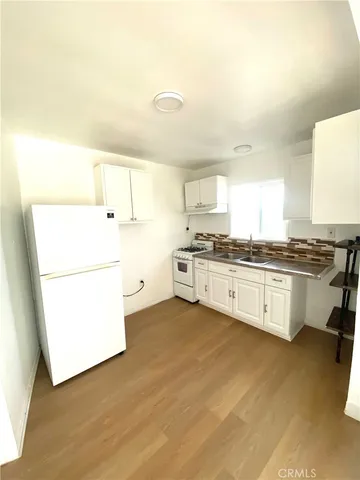 a kitchen with granite countertop white cabinets and white appliances